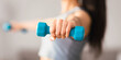 © Prostock-studio - Selective focus on light blue dumbbell in unrecognizable sporty woman hand, closeup, blurred, copy space. Cropped of athletic lady training at home. Fitness, sport activity, healthy lifestyle