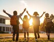 © Tasha - Excited students run toward the sunset after school with backpacks and raised arms.
