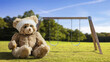 © Rawf8 - Teddy bear with bandage on head sitting alone on grass at childrens playground. Children safety concept
