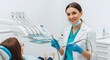© Graphic - Cheerful female dentist holding drill and smiling near patient