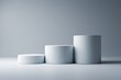 © Shabul - Three white cylinder podiums of different sizes on a white background