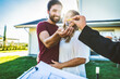 © Davide Angelini - Happy millennial couple receiving keys from realtor, purchasing real estate - Family meeting with real estate agent - New house and real estate concept