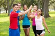 © Sanay - Group of young adults in athletic wear high fiving and smiling in a park setting outdoors