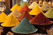 © Vitali - A close-up of colorful Iranian spices displayed in mounds at a market stall, creating a vibrant, aromatic visual.