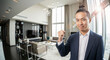 © Milan - Confident Asian businessman making a fist pump gesture in a modern luxury apartment. Successful young professional in a suit celebrating an achievement.