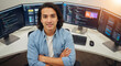 © Milan - Confident male programmer with long hair sitting in front of multiple monitors. Portrait of a young software developer with arms crossed.