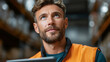 © KP - Warehouse Supervisor's Contemplation: A focused male supervisor, clad in a hi-visibility vest, is deep in thought within a warehouse setting, a symbol of focused logistics management and planning.