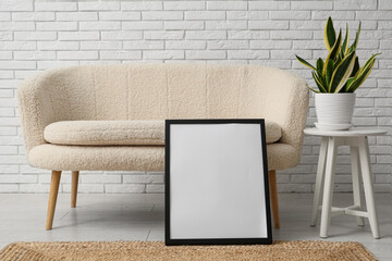 Poster - modern living room with houseplant and blank picture frame near sofa