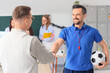 © Pixel-Shot - Male teachers shaking hands in school office