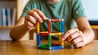 © Billing  - Child playing with colorful magnetic toy blocks building creative cube structure