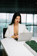 © Darius - Woman working on a laptop in a modern office setting during daytime