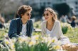 © Nutt - A Serene Outing: A couple, absorbed in an intimate conversation, leisurely enjoys a sun-drenched picnic amidst a field of daffodils. Their sunglasses shield them from the sun.