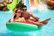 © New Africa - Happy couple with inflatable ring at water park. Summer vacation