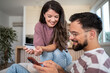 © Migma_Agency - Happy couple shopping online using credit card and smartphone at home