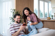 © Migma_Agency - Happy couple shopping online using credit card and smartphone at home