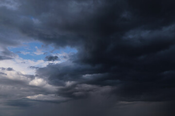 Wall Mural - Epic Dramatic storm dark grey cumulus rain clouds with blue sky, background texture, thunderstorm