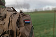 © Victor - Close-up view of military backpack with Dutch flag patch in field setting