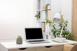 © New Africa - Stylish workplace with laptop and stationery on white table in office