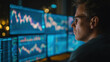 © buraratn - Focused trader analyzing stock market data on multiple screens, immersed in financial trends and charts, showcasing modern trading environment