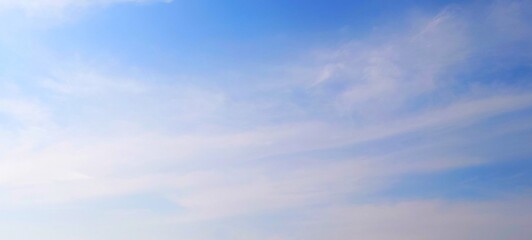 Wall Mural - Panorama view of bright blue sky with fluffy white clouds on a clear sunny day. Sky panorama clear blue with white clouds in spring. Cloudscape. Clear blue sky, bright spring, wallpaper landscape.