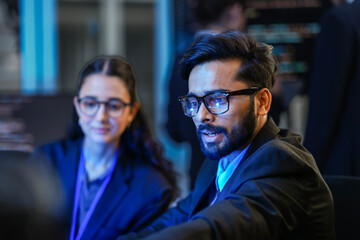 diverse ai developers collaborate in a late-night coding session. a senior engineer mentors his coll