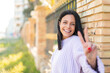 © luismolinero - Young woman at outdoors smiling and showing victory sign