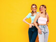 © halayalex - Two young beautiful smiling blond hipster female in trendy summer clothes. Sexy carefree women posing near yellow wall in studio. Positive models having fun. Cheerful and happy. In sunglasses