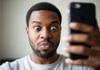 © SERHII - Surprised Young Black Man Gazing at Smartphone with Excitement
