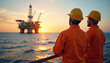 © miss irine - Men in yellow and white hard hats stand on gray platform overlooking ocean. Oil rig with crane in background. Workers inspect machinery in industrial setting.