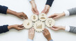 © Kaluya Stock - Diverse hands collaboratively hold a network of wooden gears with business icons (growth, finance, idea, people), representing teamwork and a shared strategy on a white background
