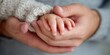 © Phatcharee - Tender moment parent and child hand holding home environment emotional connection close-up