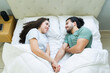 © AntonioDiaz - Loving couple holding hands and talking in bed in the morning