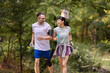 © lordn - Happy diverse couple jogging outdoors in a park, smiling and enjoying an active lifestyle together on a sunny day