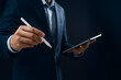 © Hunaif - Businessman in suit holding a tablet and stylus, seemingly writing or drawing on the device.