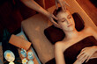© InfiniteFlow - Caucasian woman enjoying relaxing anti-stress head massage and pampering facial beauty skin recreation leisure in warm candle lighting ambient salon spa in luxury resort or hotel. Quiescent