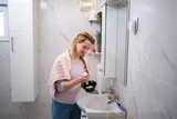 Pregnant woman preparing hair dye in bathroom