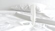 © Cinta - A single white feather on a bed of white sheets