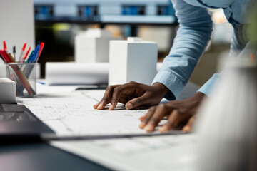 close up of black woman contractor examining layout blueprints for a new residential construction, s