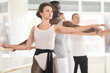 © JackF - Men and women stand in second position near ballet barre during group training in a dance studio
