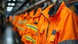 © Daisha - Orange safety jackets hanging in industrial facility; background blurred