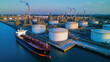 © Kosin - Aerial view of large oil refinery with storage tanks and tanker ship docked nearby, showcasing industrial infrastructure and energy production. scene conveys sense of scale and activity