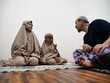 © airdone - Asian muslim father talking to his daughters after salah pray, communication discussion giving advice