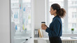 © Olga - Businesswoman holding coffee in office
