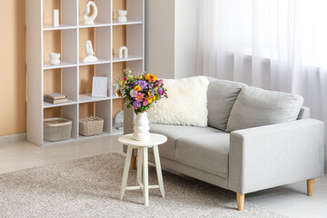 Poster - sofa, shelving units and vase with wild flowers on coffee table in living room