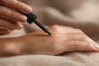 © Руслан Галиуллин - Close-up of female hand applying golden oil by dropper, skin care, skin hydration
