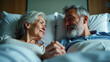 © Aleksandra - Elderly couple holding hands in a hospital bed - last moments together