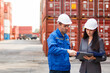 © DG PhotoStock - Team of engineers or workers at a container yard discussing seriously and shaking hands to symbolize teamwork and business success.