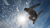 snowboarder mid-air jump, powder snow flying
