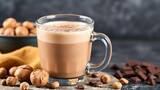 Hazelnut hot chocolate in a glass mug with hazelnuts and dark chocolate chunks nearby