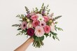©  AugmentArt - Close-up of a woman grasping a large stunning spring bridal bouquet featuring various vibrant fresh blossoms on a plain white backdrop with ample copy space. Floral arrangement artistry concept.